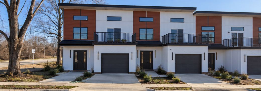 Six-unit townhouse building in Jeffersonville, Indiana, with brick-red upper panels and garages