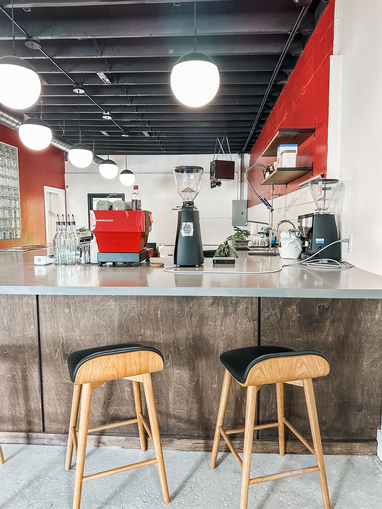 Not Another Film Lab in Orlando: service counter with stools, red wall, and espresso machine