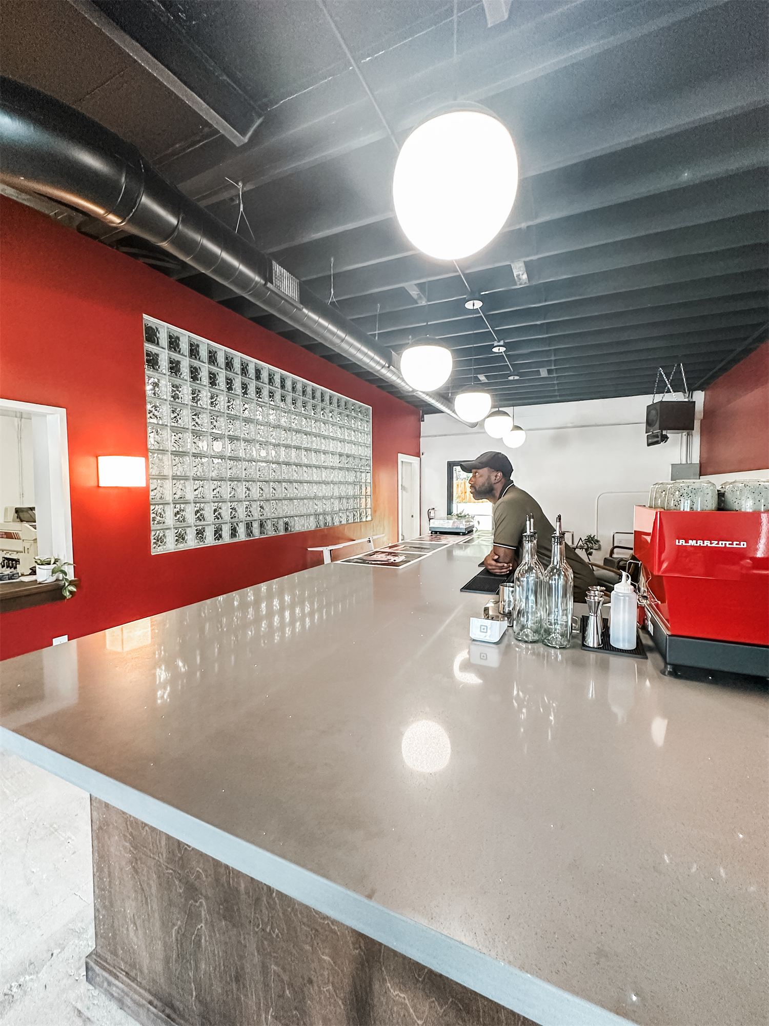 Customer counter at Not Another Film Lab in Orlando with red accent wall and pendant lights