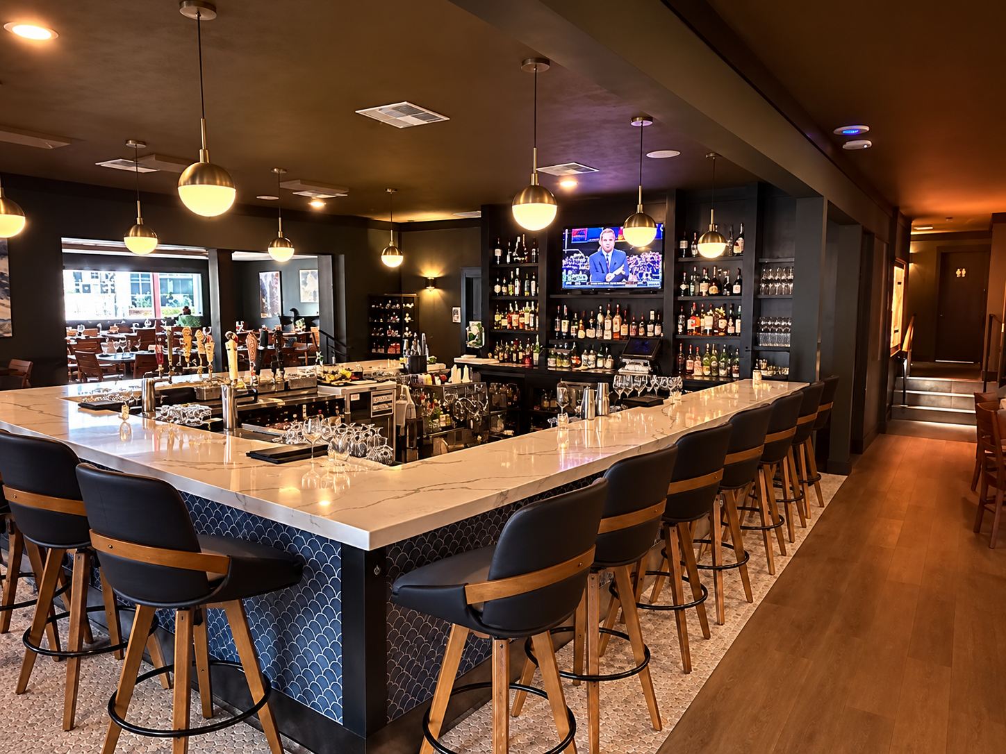 Bar at Salt & Ember restaurant in Mount Dora with a long stone counter and pendant lighting